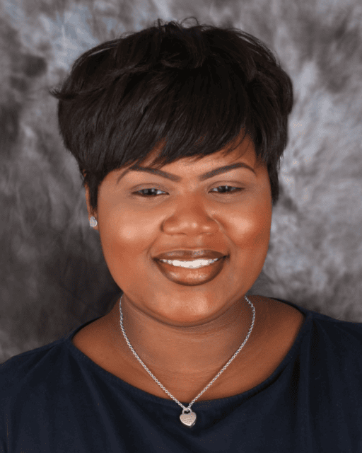 A woman with short dark hair is smiling, representing support for Louisiana citizens with developmental disabilities.